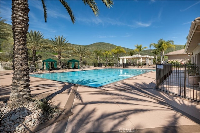 view of pool with a mountain view and a pergola