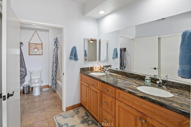 bathroom featuring double vanity, tile patterned flooring, toilet, and a sink