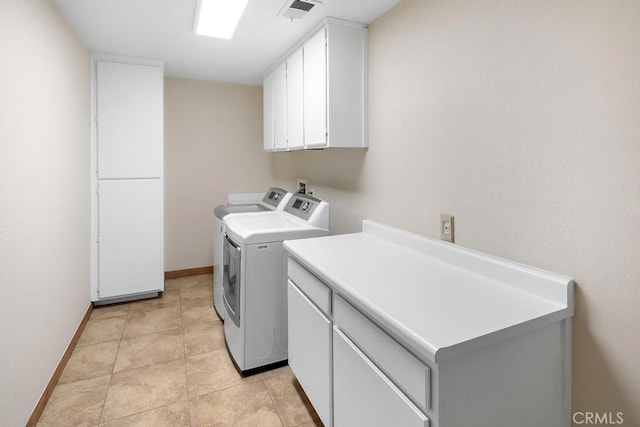 laundry area featuring light tile patterned floors, washing machine and dryer, visible vents, baseboards, and cabinet space