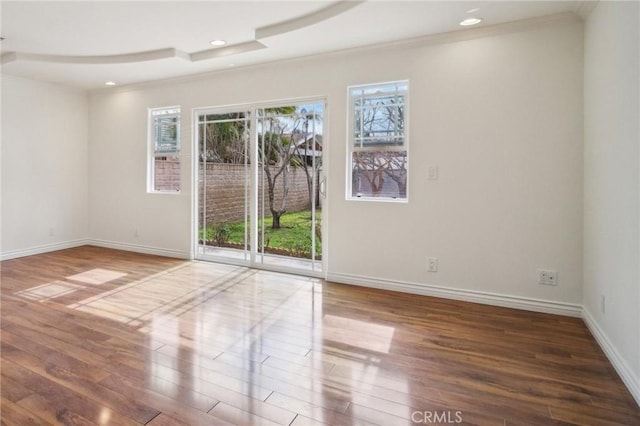 empty room featuring hardwood / wood-style flooring and crown molding