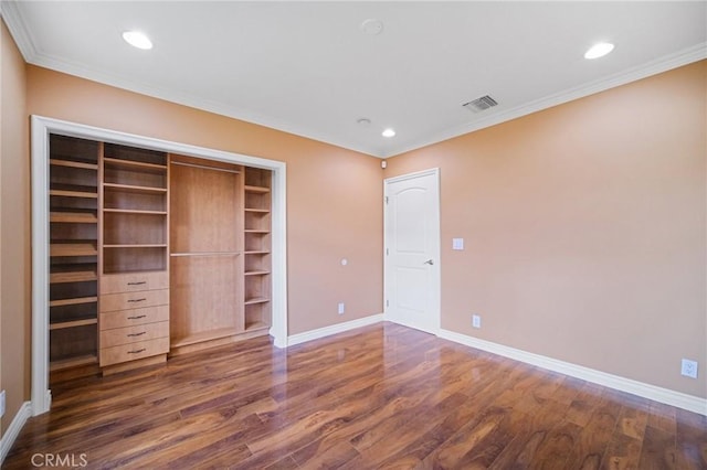 unfurnished bedroom featuring dark wood-type flooring, crown molding, and a closet