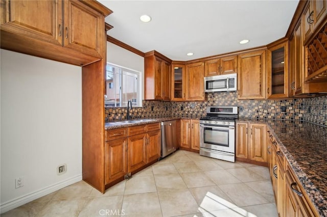 kitchen featuring dark stone countertops, sink, tasteful backsplash, and appliances with stainless steel finishes