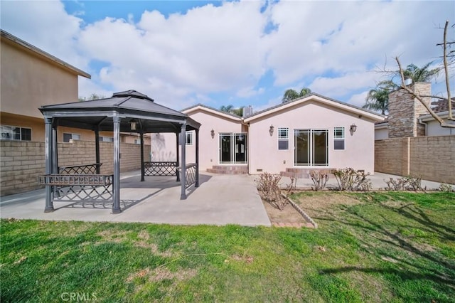 rear view of property featuring a gazebo, a yard, and a patio area