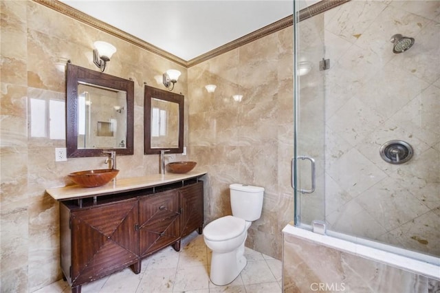 bathroom featuring crown molding, tile walls, vanity, a shower with shower door, and toilet