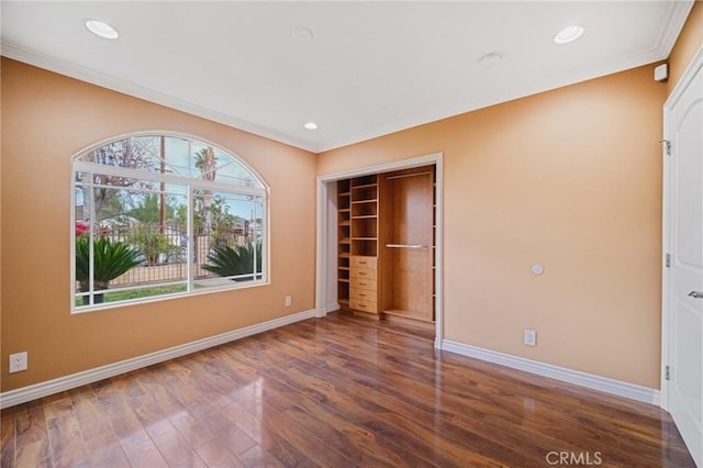 unfurnished bedroom featuring ornamental molding, dark hardwood / wood-style floors, and a closet