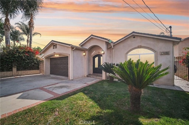 view of front of home featuring a garage and a lawn