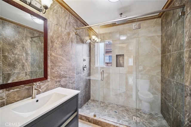 bathroom with vanity, an enclosed shower, and tile walls