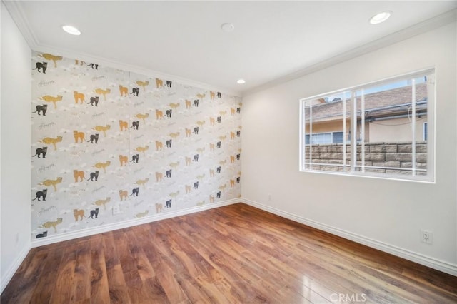 spare room with crown molding and wood-type flooring