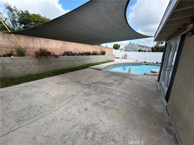 view of swimming pool featuring a fenced backyard, a patio, and a fenced in pool