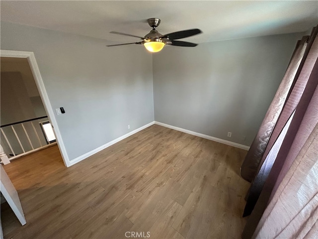 unfurnished bedroom with a ceiling fan, baseboards, and wood finished floors