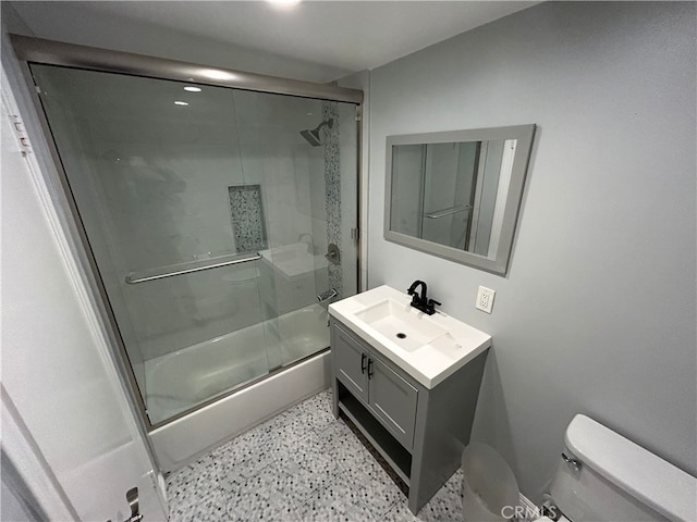 full bathroom with toilet, vanity, combined bath / shower with glass door, and speckled floor
