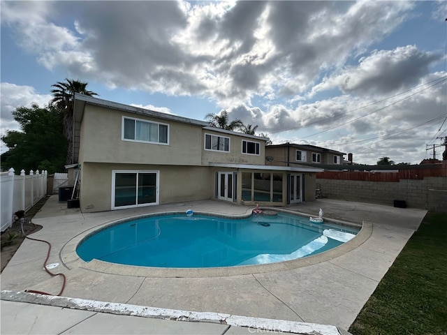 view of swimming pool featuring a fenced backyard, a patio, french doors, and a fenced in pool