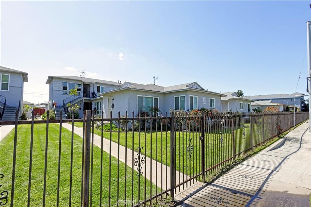 view of front of home featuring a fenced front yard, a residential view, and a front yard