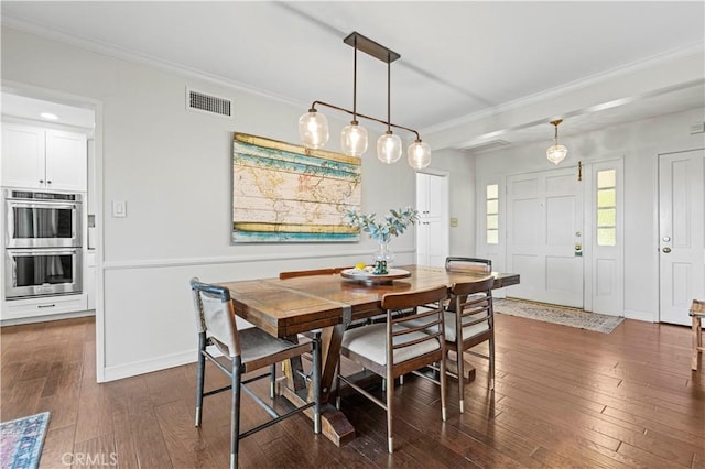 dining room featuring crown molding and dark wood-type flooring