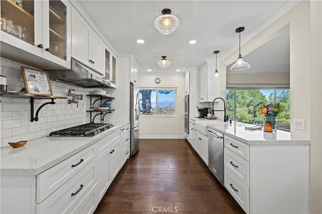 kitchen featuring decorative light fixtures, sink, white cabinets, stainless steel appliances, and dark wood-type flooring