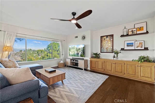 living room featuring ceiling fan and dark hardwood / wood-style flooring