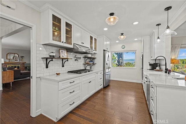 kitchen with stainless steel appliances, decorative light fixtures, light stone countertops, and white cabinets