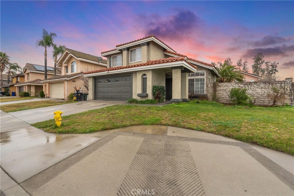 mediterranean / spanish house with a garage and a lawn