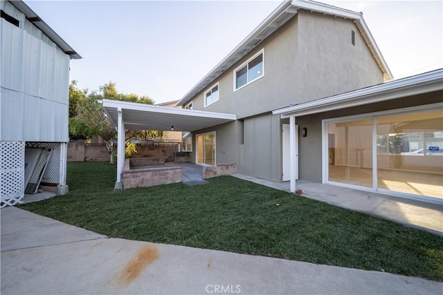 back of house featuring stucco siding, a patio, fence, and a lawn