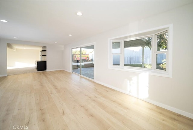 unfurnished living room with light wood-style flooring, baseboards, and recessed lighting