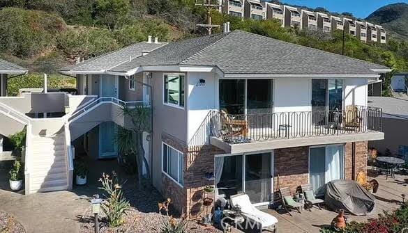 rear view of house featuring a patio area and a balcony