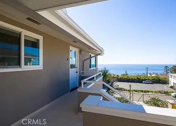 view of patio / terrace featuring a water view and a balcony