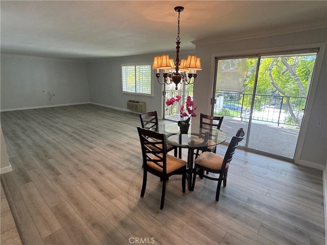 dining room with baseboards, wood finished floors, a wall mounted air conditioner, crown molding, and a notable chandelier