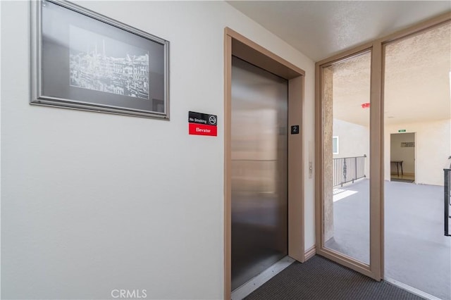 2381 Via Mariposa W Unit 2C, Laguna Woods, CA 92637 - hallway featuring carpet, elevator, and baseboards