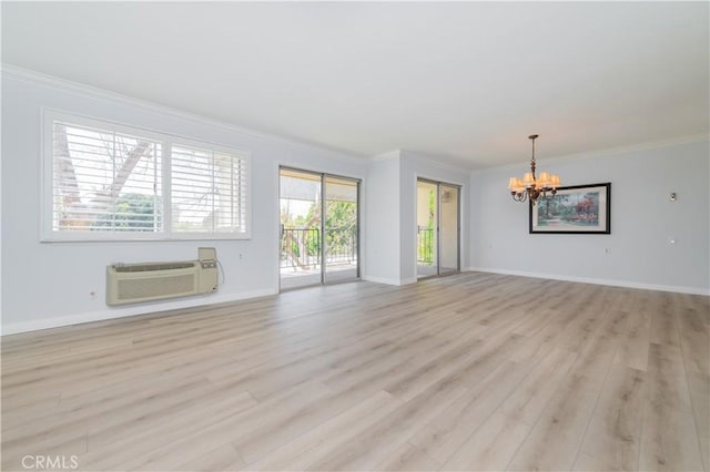 2381 Via Mariposa W Unit 2C, Laguna Woods, CA 92637 - unfurnished living room featuring a chandelier, a wall unit AC, crown molding, light wood-style flooring, and baseboards