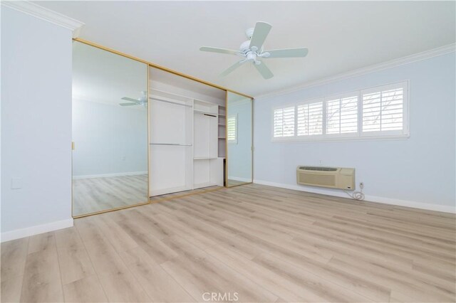 2381 Via Mariposa W Unit 2C, Laguna Woods, CA 92637 - unfurnished bedroom with ornamental molding, light wood finished floors, baseboards, a wall mounted AC, and a closet