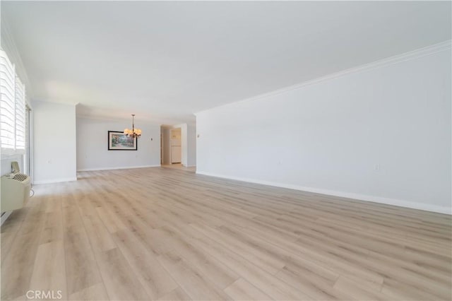 2381 Via Mariposa W Unit 2C, Laguna Woods, CA 92637 - unfurnished living room featuring a chandelier, light wood-style flooring, baseboards, and crown molding