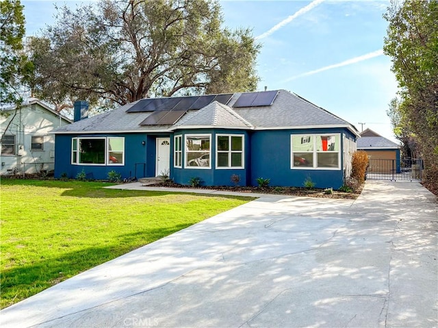 single story home featuring a front lawn and solar panels