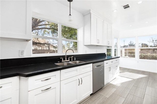 kitchen with white cabinetry, sink, decorative light fixtures, and stainless steel dishwasher