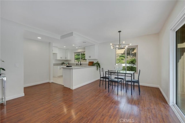 dining room with an inviting chandelier, baseboards, dark wood-type flooring, and recessed lighting