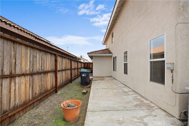 view of home's exterior featuring a tile roof, a patio area, a fenced backyard, and stucco siding