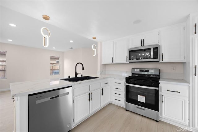 kitchen featuring a peninsula, stainless steel appliances, and a sink