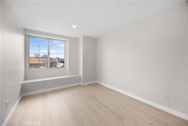 unfurnished room with light wood-style floors, recessed lighting, and baseboards