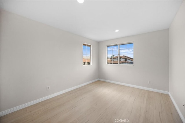 unfurnished room with light wood-style floors, baseboards, and recessed lighting