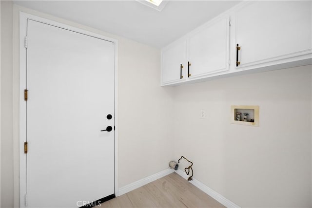 laundry room featuring light wood-style flooring, washer hookup, cabinet space, and baseboards