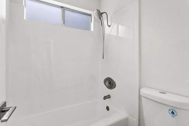 bathroom featuring shower / bathtub combination and toilet