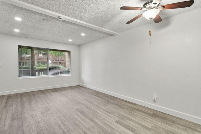 empty room with ceiling fan, a textured ceiling, and light hardwood / wood-style flooring