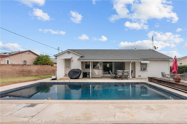 back of property featuring a fenced in pool and a patio