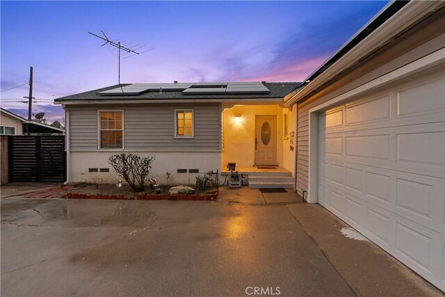 view of front of property with a garage and solar panels