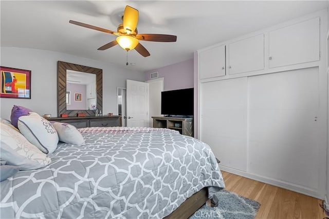 bedroom featuring ceiling fan, a closet, and light wood-type flooring