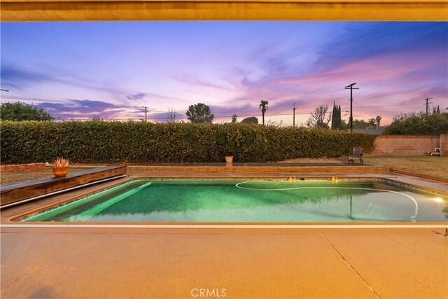 view of pool at dusk