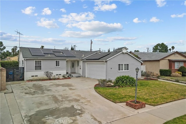 ranch-style house with a garage, a front lawn, and solar panels