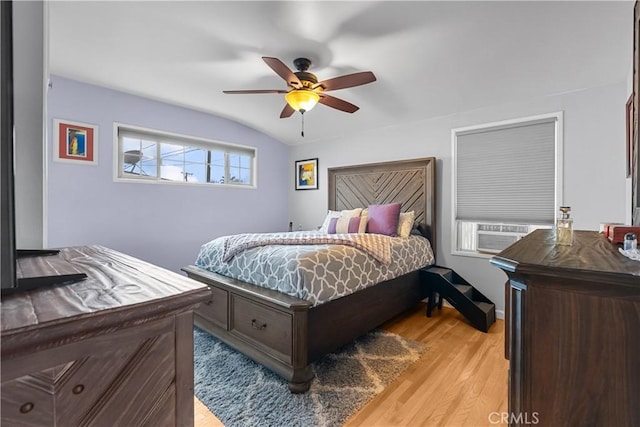 bedroom with vaulted ceiling, cooling unit, ceiling fan, and light hardwood / wood-style flooring