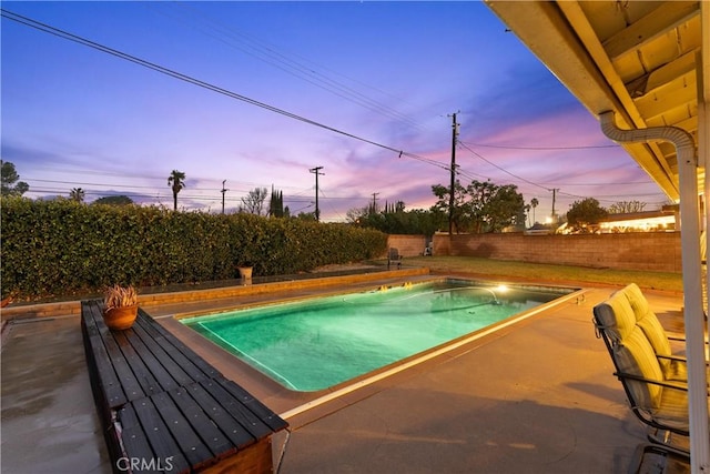 pool at dusk with a patio