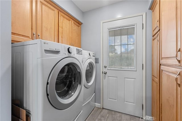 laundry room featuring cabinets, separate washer and dryer, and light hardwood / wood-style floors