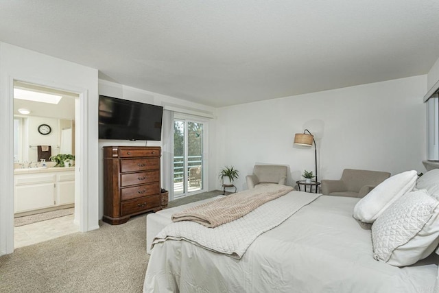 bedroom with light carpet, sink, ensuite bath, and a skylight